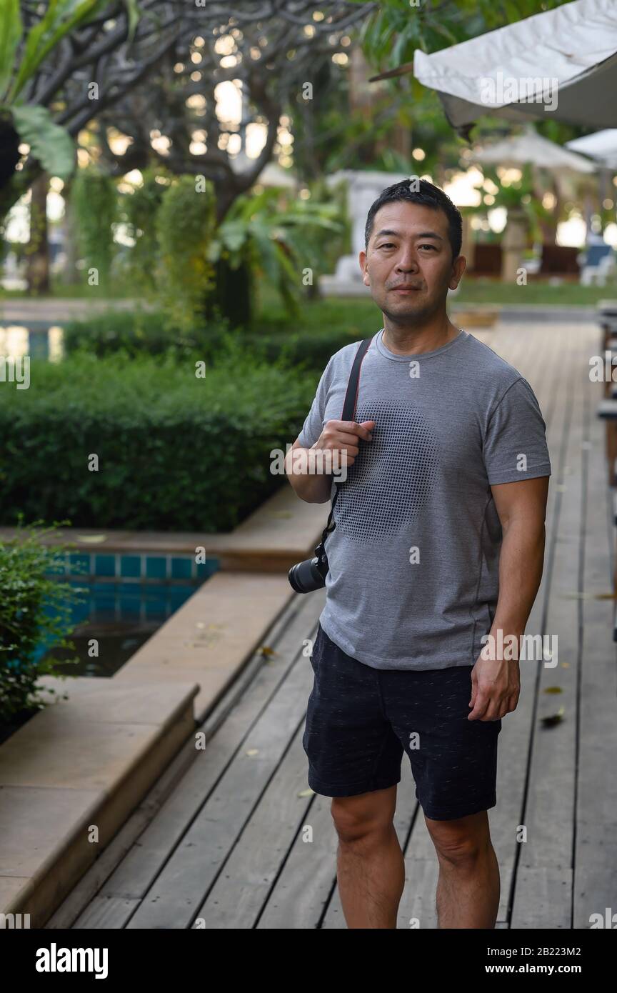 Ein japanischer Mann mit Kamera genießt das Abendleben am Strand in Pattaya, Thailand Stockfoto