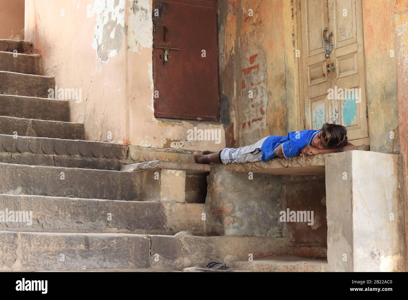 Ein Mann schläft außerhalb des Hauses Stockfoto