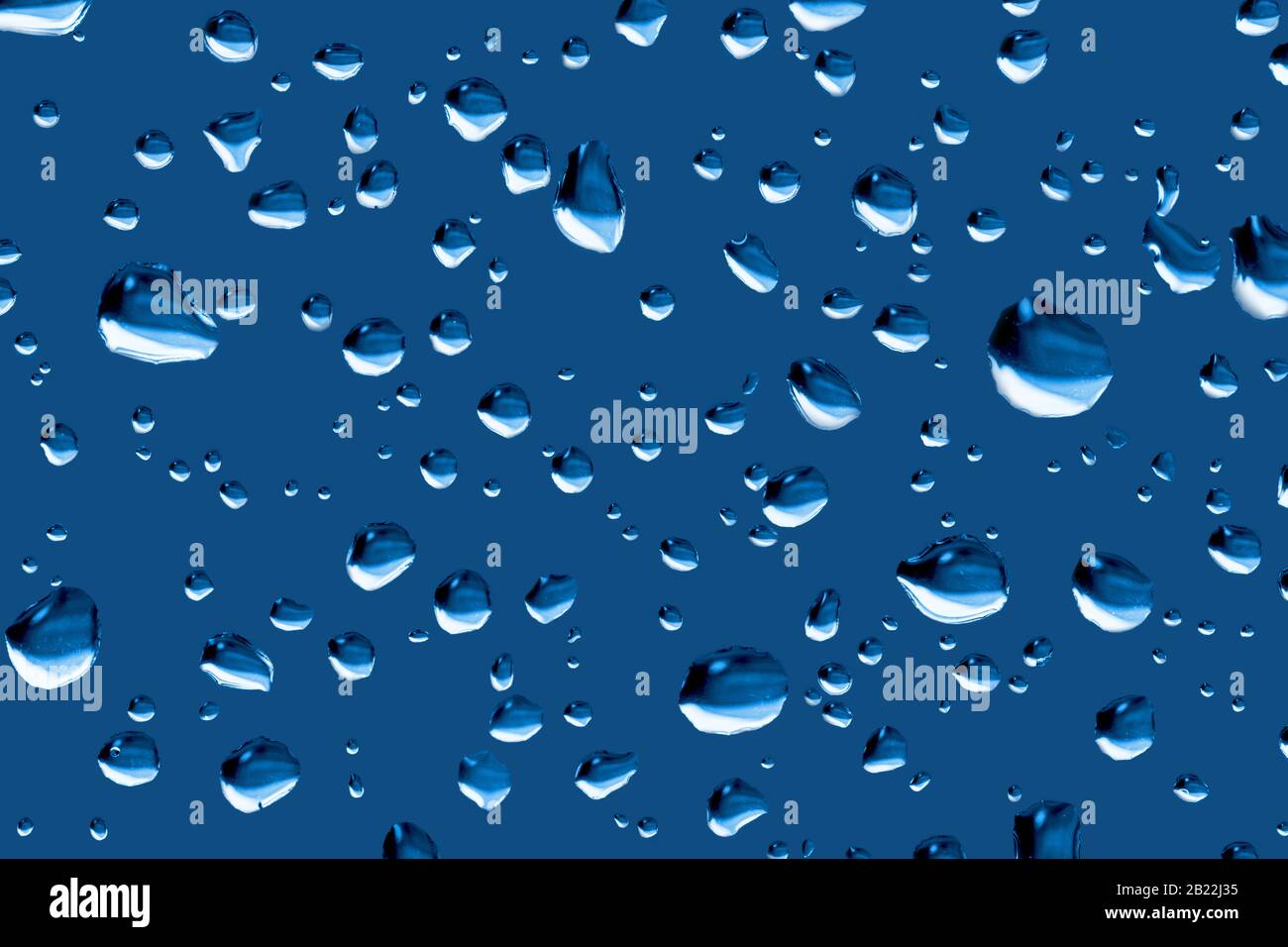 Regentropfen auf einer Fensterfarbe, angepasst an Pantone 19-4052 Classic Blue, Farbe des Jahres 2020. Pantone Farbe des Jahres 2020. Stockfoto