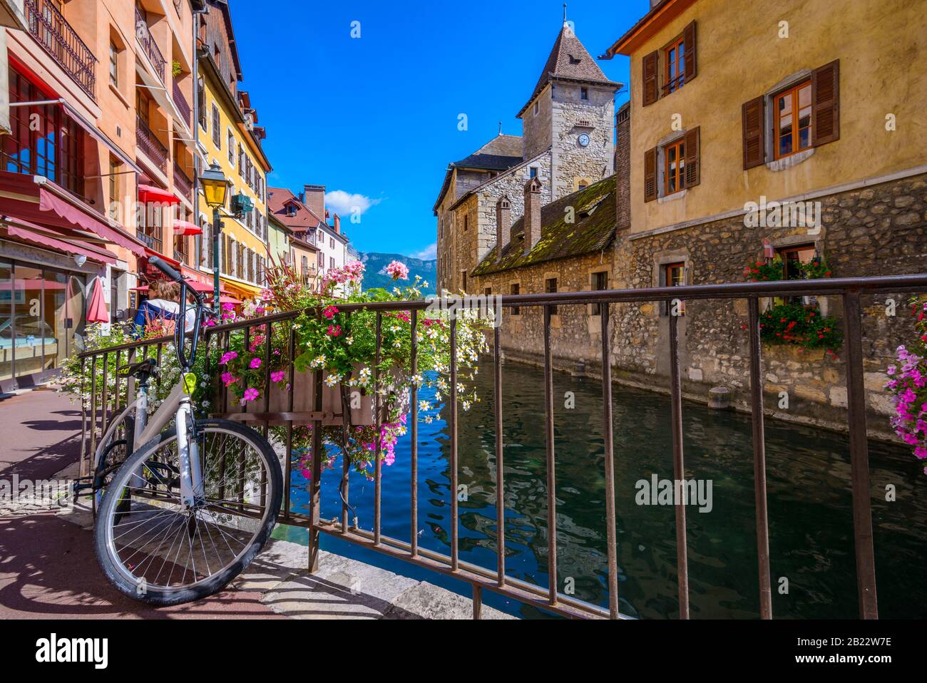 Die Rückseite des Palais de l'Ile mit einem Fahrrad im Vordergrund von der Passage de l'Ile über den Fluss Thiou, Annecy, Frankreich, an einem hellen Septembertag Stockfoto
