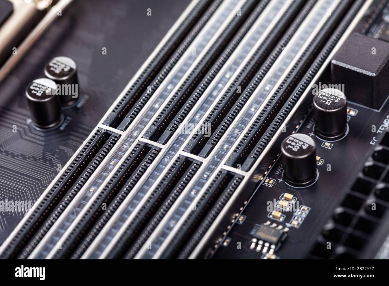 Schließen Sie leere RAM-Steckplätze auf einem modernen schwarzen silberfarbenen Motherboard ab. DDR4-, ddr5-Speichersteckplätze mit wahlfreiem Zugriff, RAM-Platzierung. Makroelektronik Stockfoto