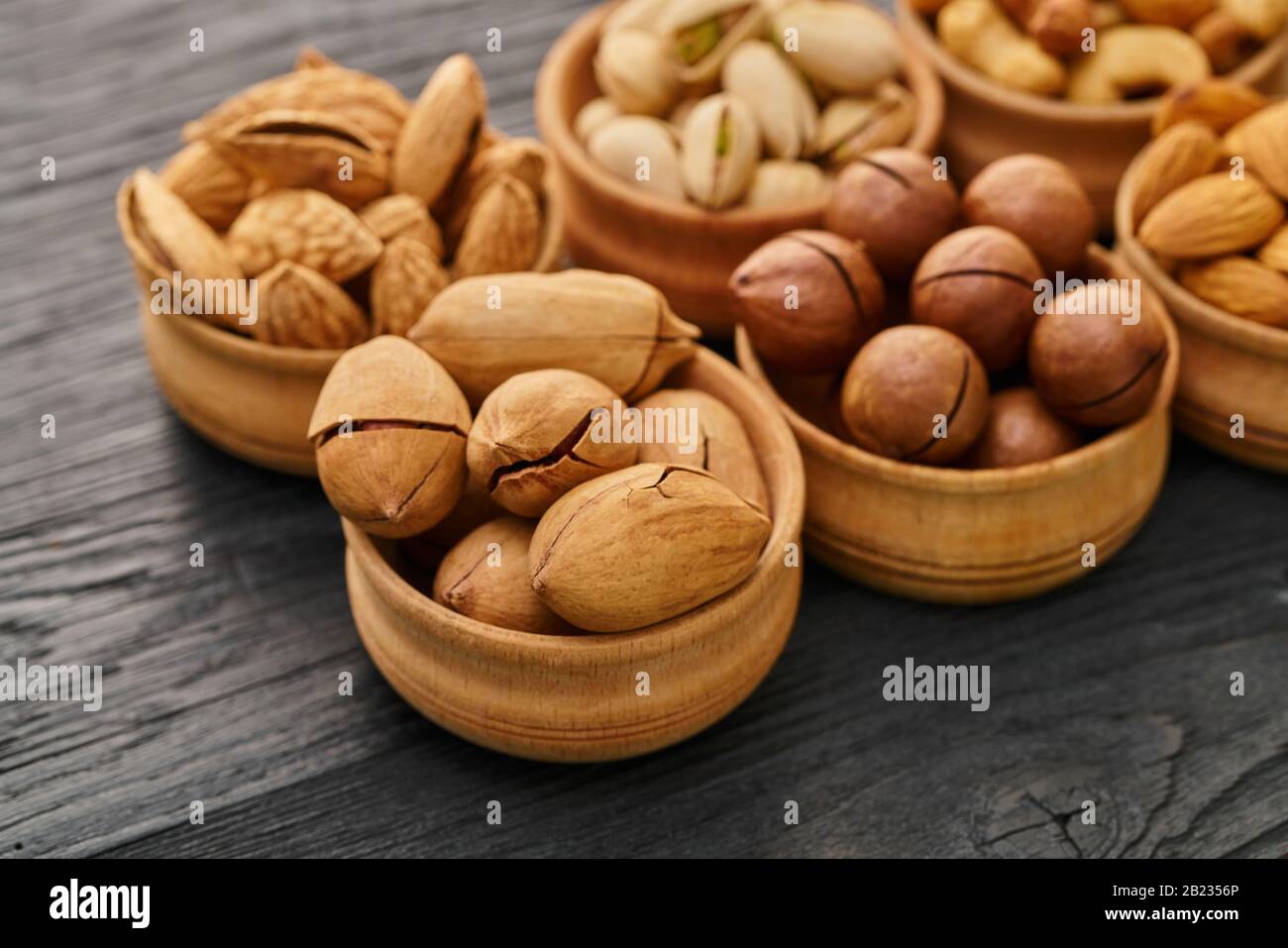 Nussset in einer Schüssel auf schwarzem Holzhintergrund Stockfoto