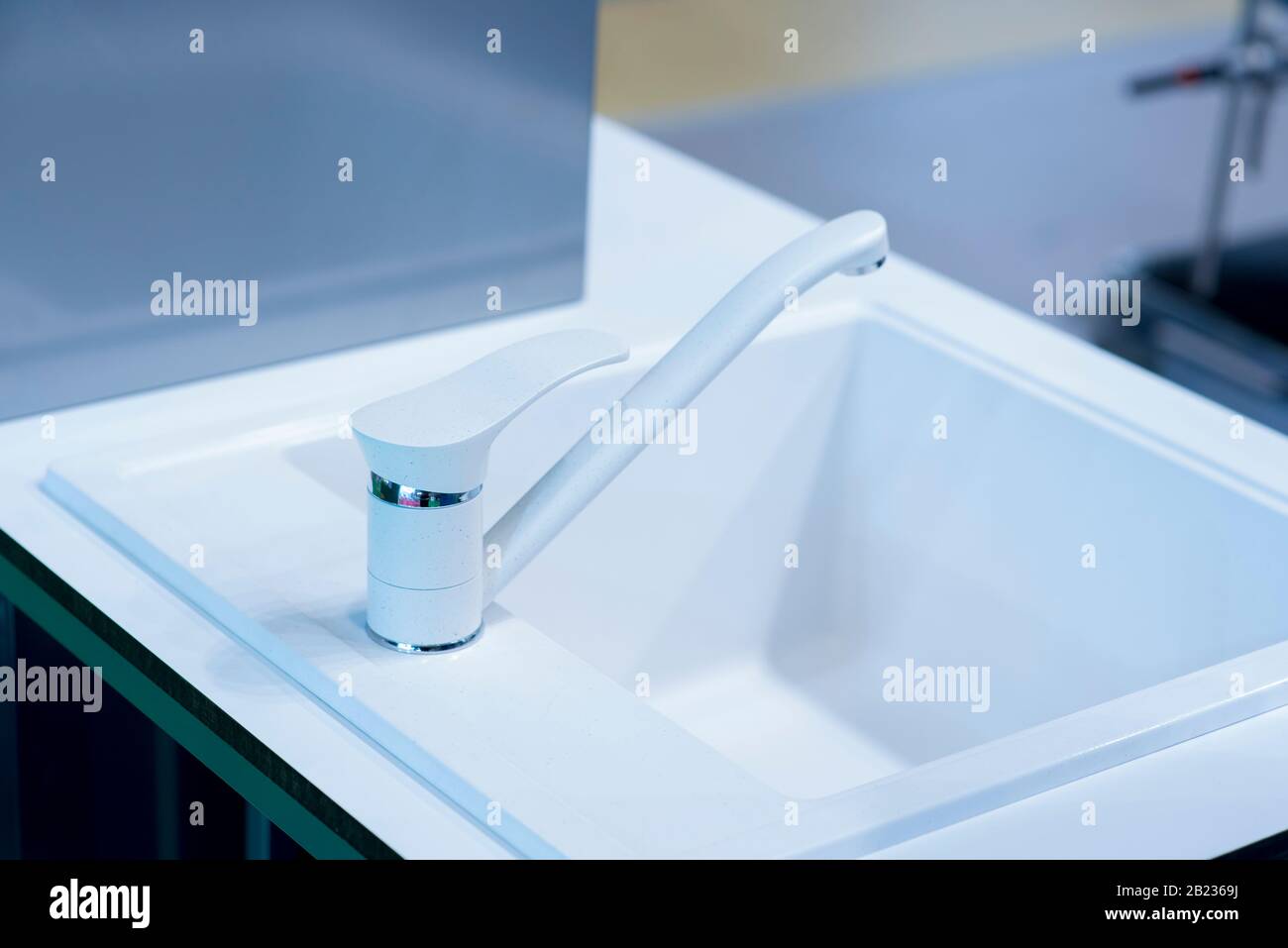 Modernes Waschbecken aus künstlichem weißem Stein, Modernes minimalistisches Waschbecken mit Chrombatterien, Bad mit modernem Waschbecken. Stockfoto