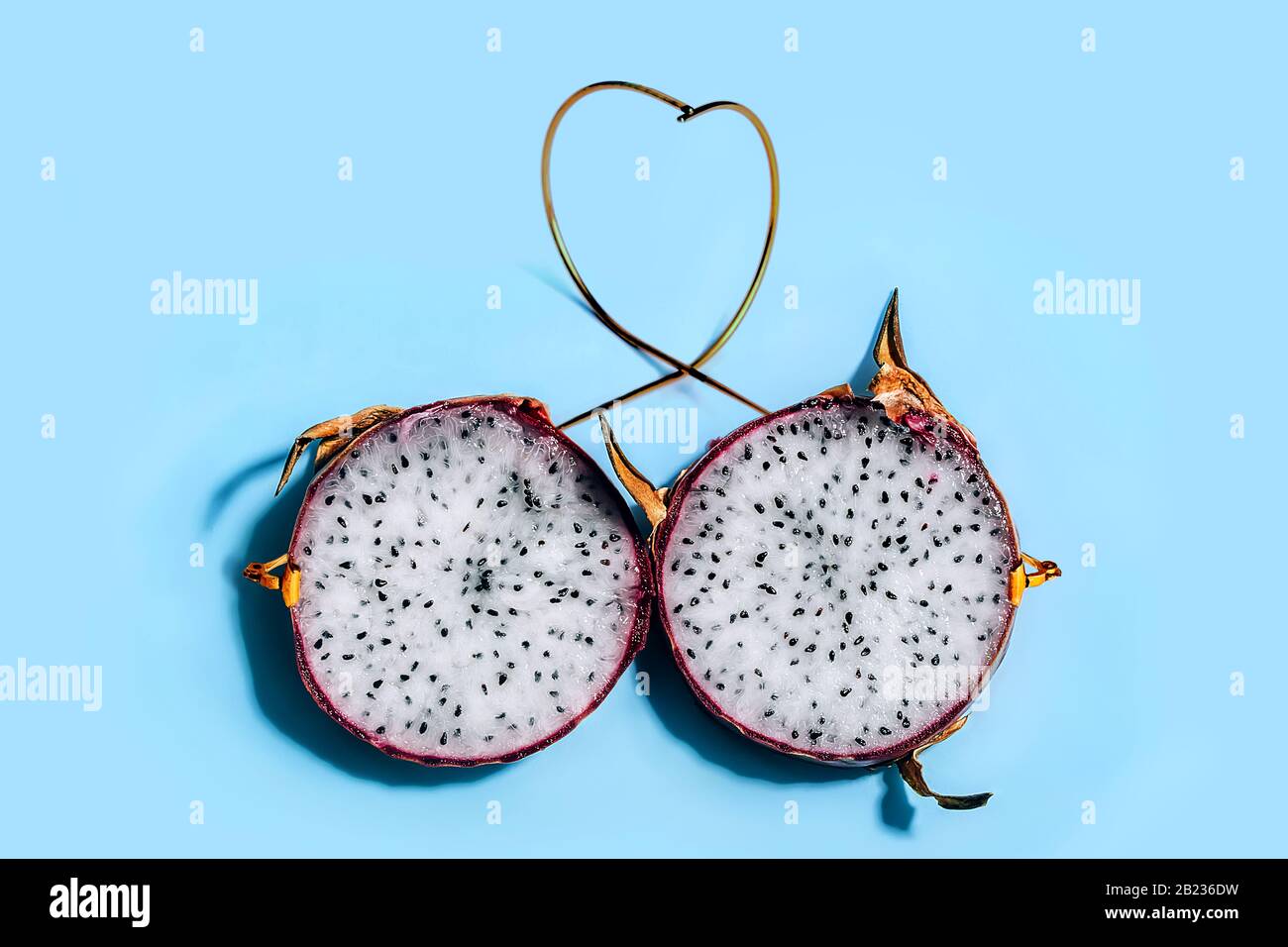Zwei Scheiben Drachenfrucht Oder Pitaya In Der Haut Mit Goldenen Bugeln Die Eine Brille Auf Blauem Grund Darstellen Augenheilkunde Und Gesundheitskonzept Stockfotografie Alamy