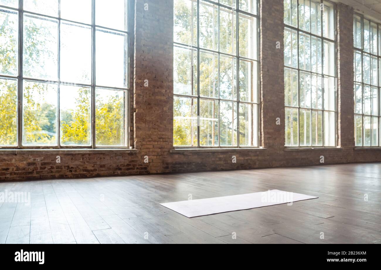 Weiße Matte auf Holzboden im modernen Fitnessstudio. Stockfoto