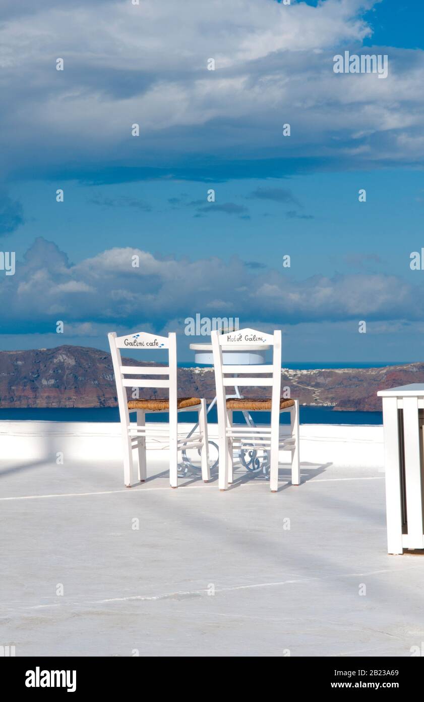 Postkartenidylle - zwei weisse Stuehle mit Blick auf Santorin Stockfoto