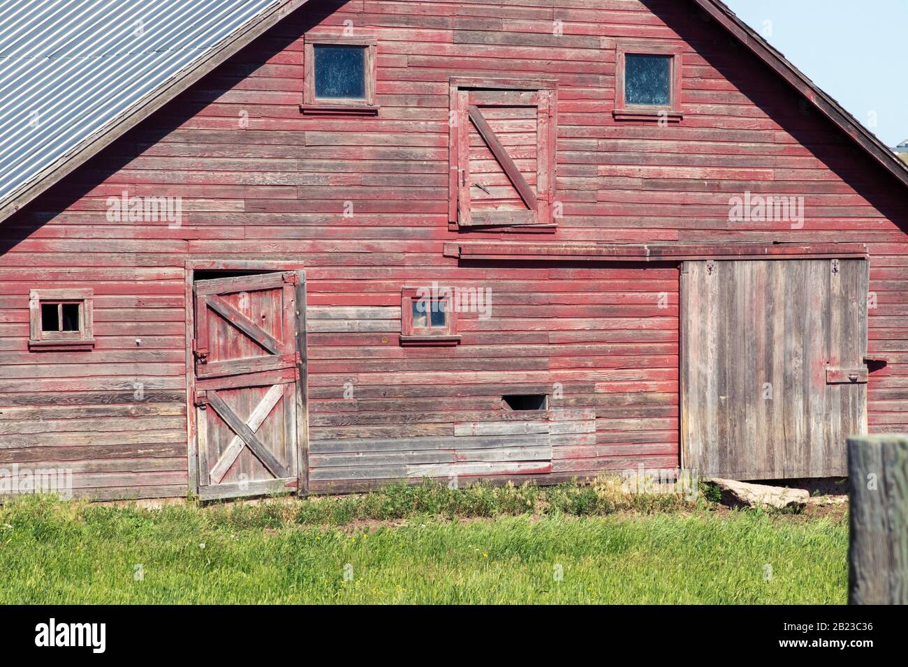 Eine große alte Abbaufeune mit Gras vor einem Haus. Hochwertige Fotos Stockfoto