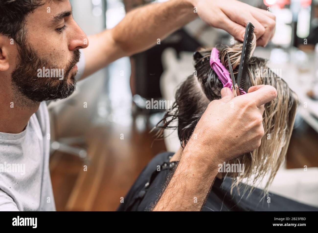 Friseursalon kürzt blonde Frau im Salon. Nahaufnahme des Fotos. Stockfoto