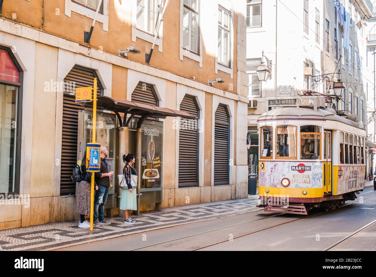 Touristen warten auf die gelbe Straßenbahn 28 in der Nähe der rua augusta in lissabon portugal Stockfoto