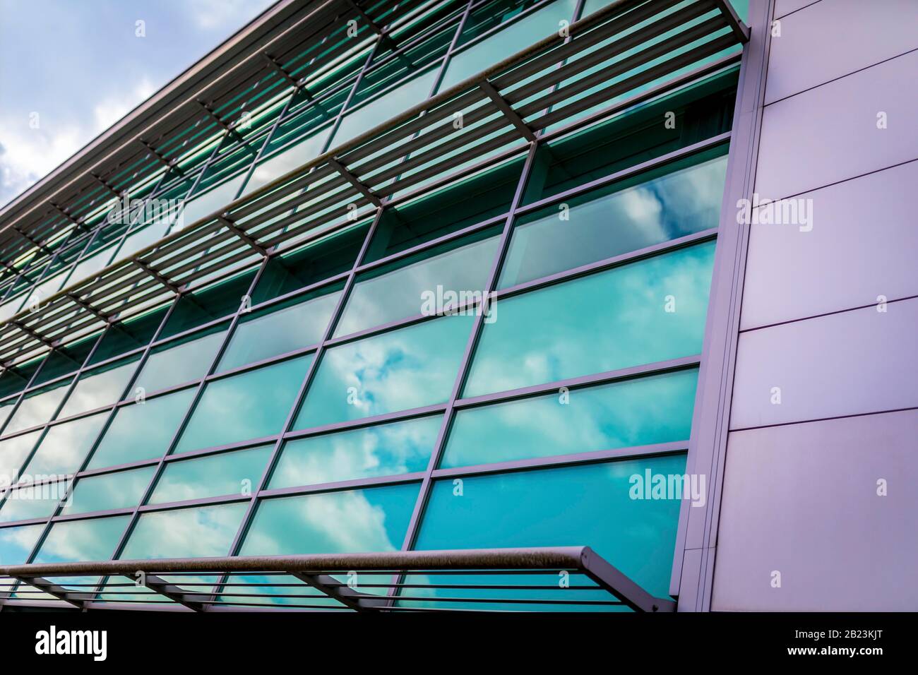 Modernes Gebäude in architektonischer Struktur, Unterkunftsgebäude mit Außenverkleidung und Metallträger mit modernen reflektierenden Fenstern A Stockfoto