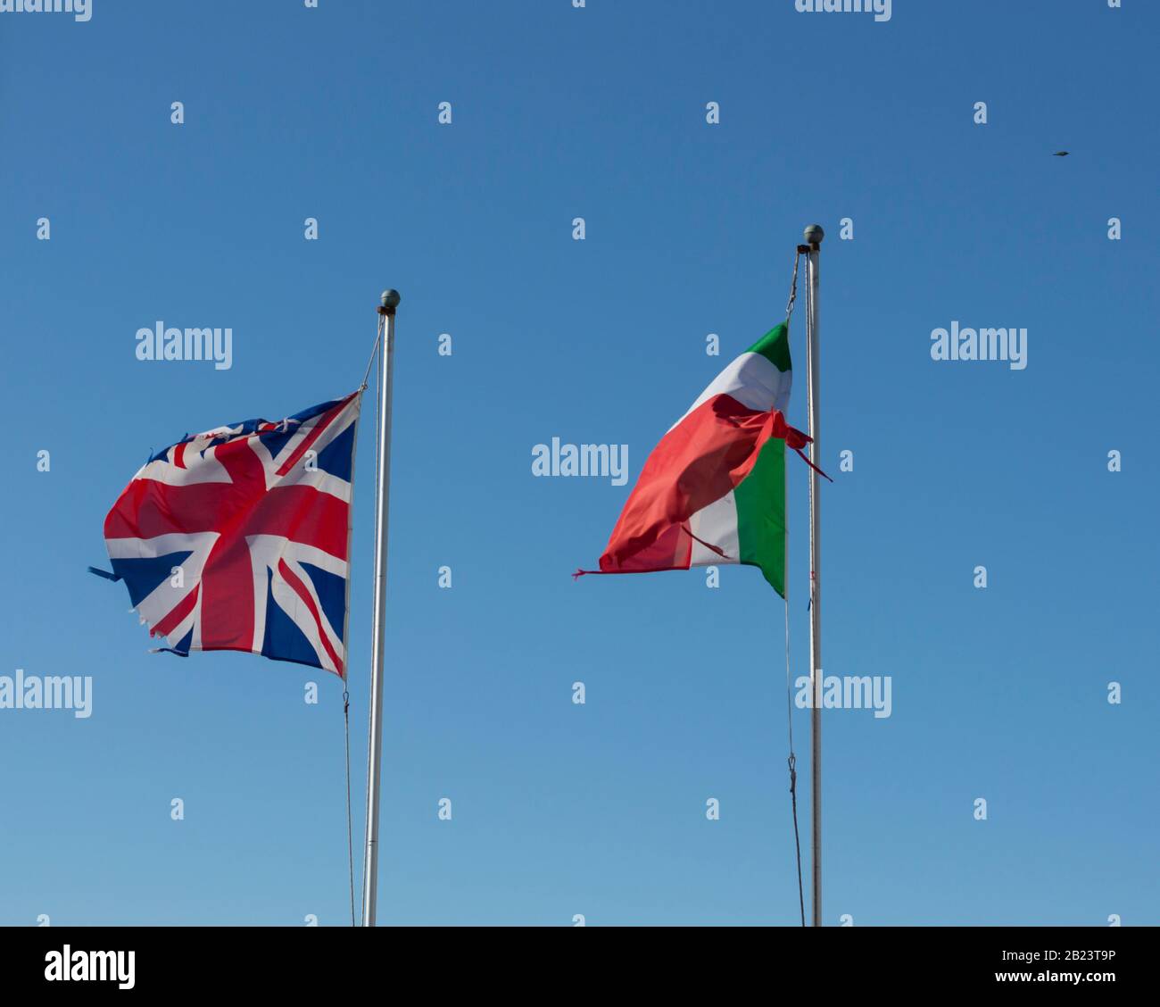 Flaggen Großbritanniens und Italiens winken vor blauem Himmel Stockfoto