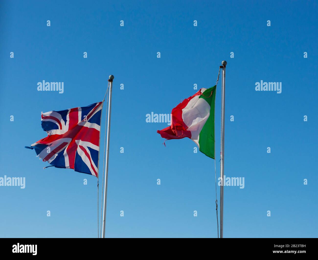 Flaggen Großbritanniens und Italiens winken vor blauem Himmel Stockfoto