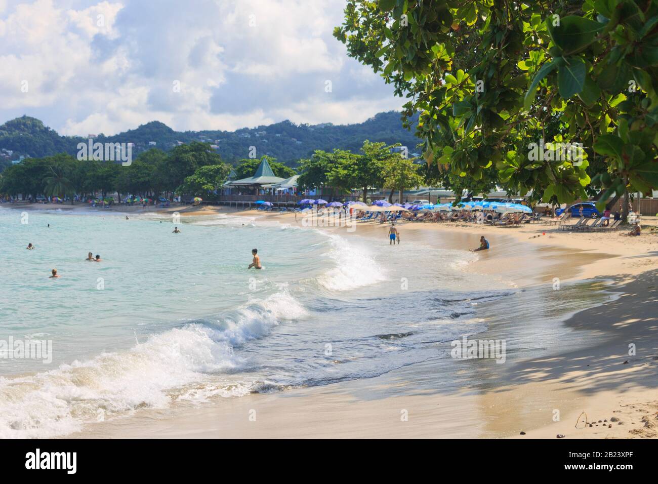 Castries, Saint Lucia - 23. November 2019. Touristen in Vigie Beach an einem hellen Sommertag, einige unter dem Schatten eines GESPONSERTEN Regenschirms Stockfoto