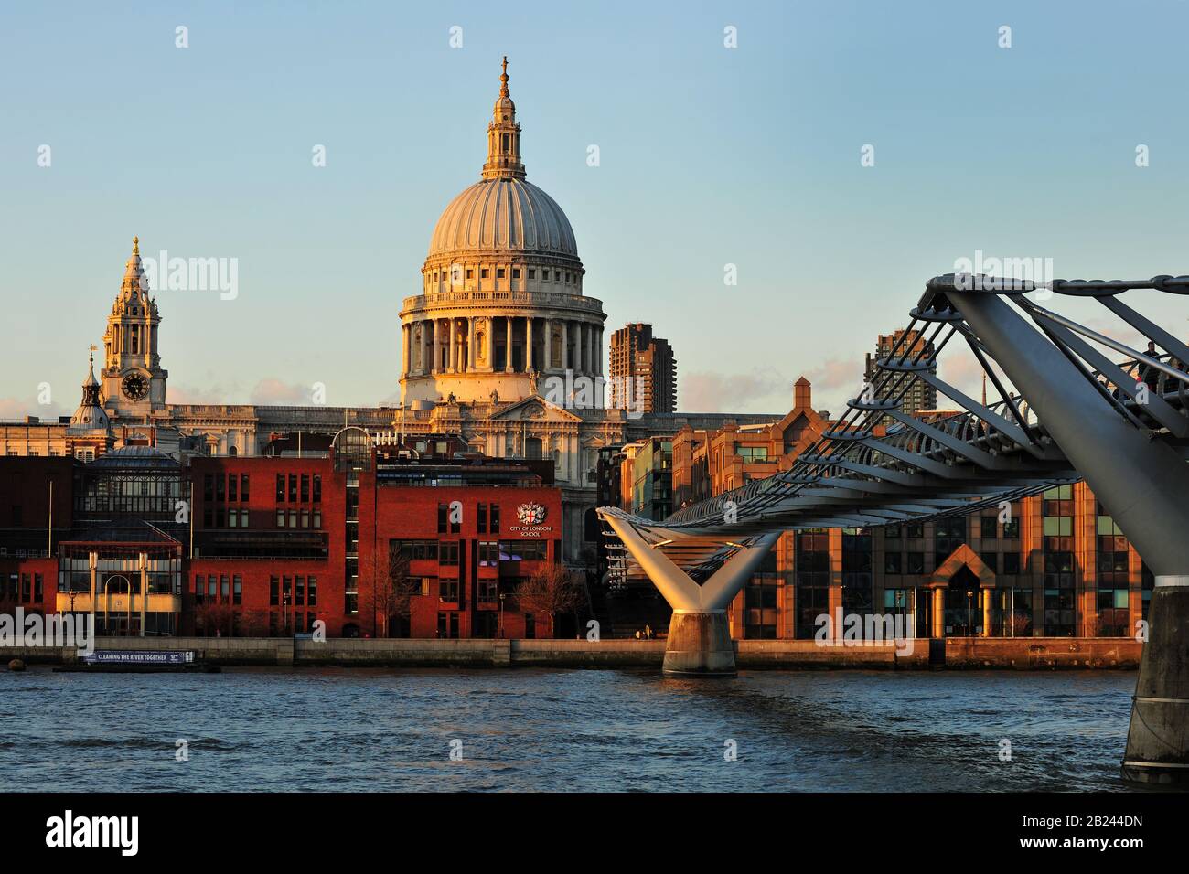 Ein Landschaftsbild der St Paul's Cathedral und der Millennium Bridge London vom gegenüberliegenden Ufer der Themse bei Sonnenuntergang. Stockfoto