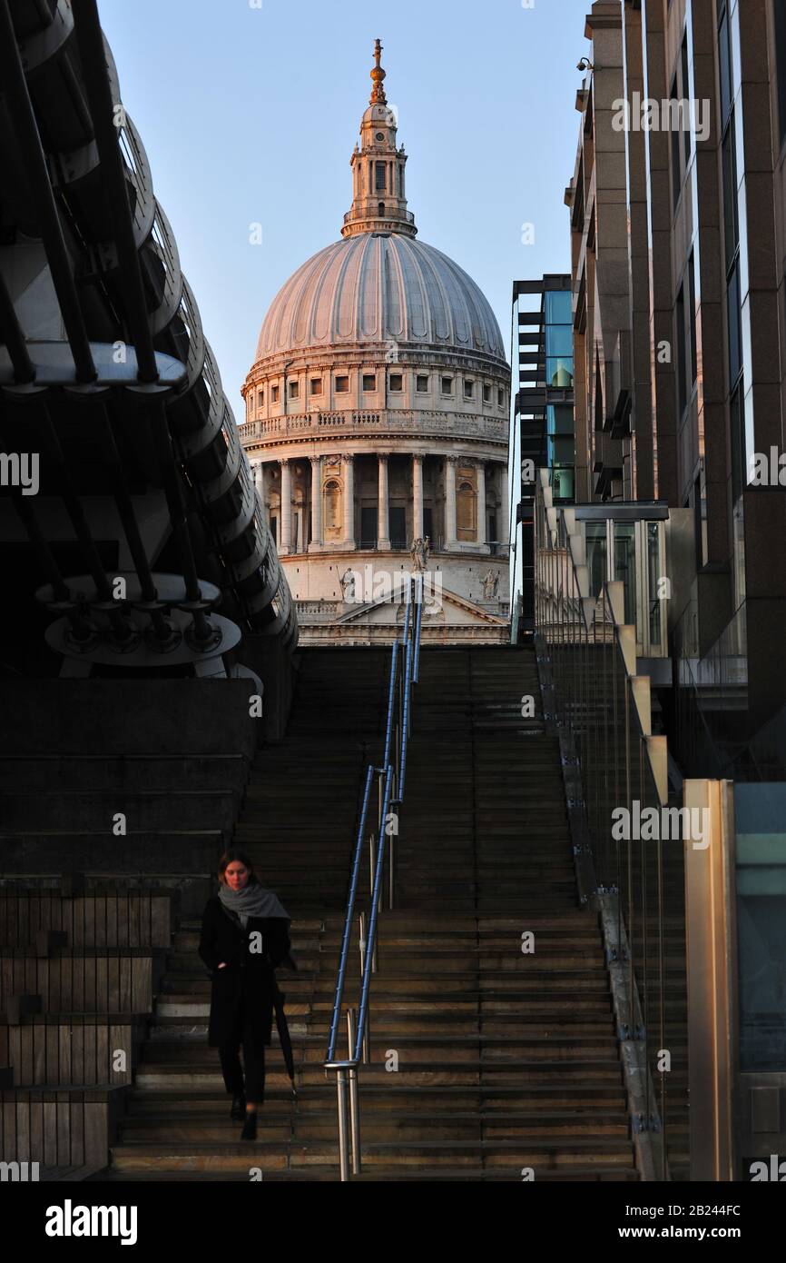 St Paul's Cathedral, London. Mit einer Person im Vordergrund, die die Treppe zur Millennium Bridge aufsteigt. Stockfoto