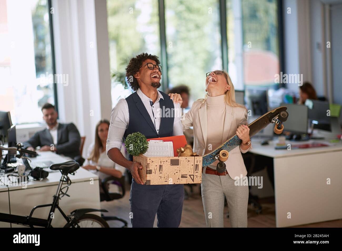 Fröhliche junge, vielseitige Kollegen tanzen mit Spaß im Büro.neuer Job bei modernen Unternehmen. Stockfoto