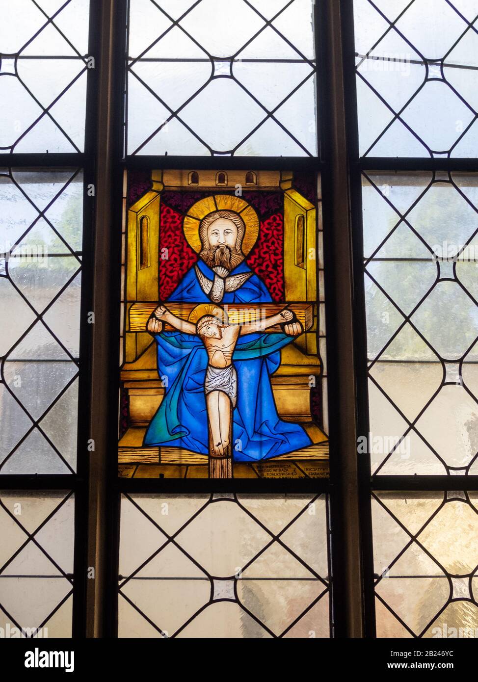 Kleine Glasmalerei mit Christus am Kreuz und Heiliger Stockfoto
