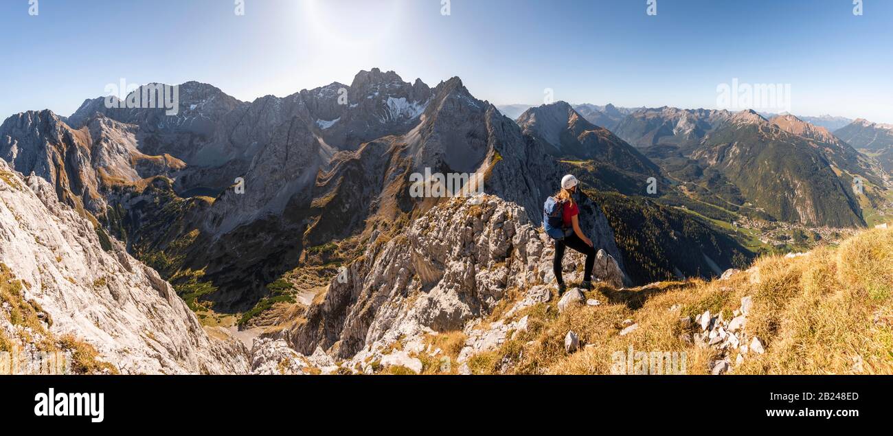 Junge Frau, Bergsteigerin mit Kletterhelm mit Blick auf die Berglandschaft, Wanderung zur Ehrwalder Sonnenspitze, hinter Gruenstein und West Stockfoto