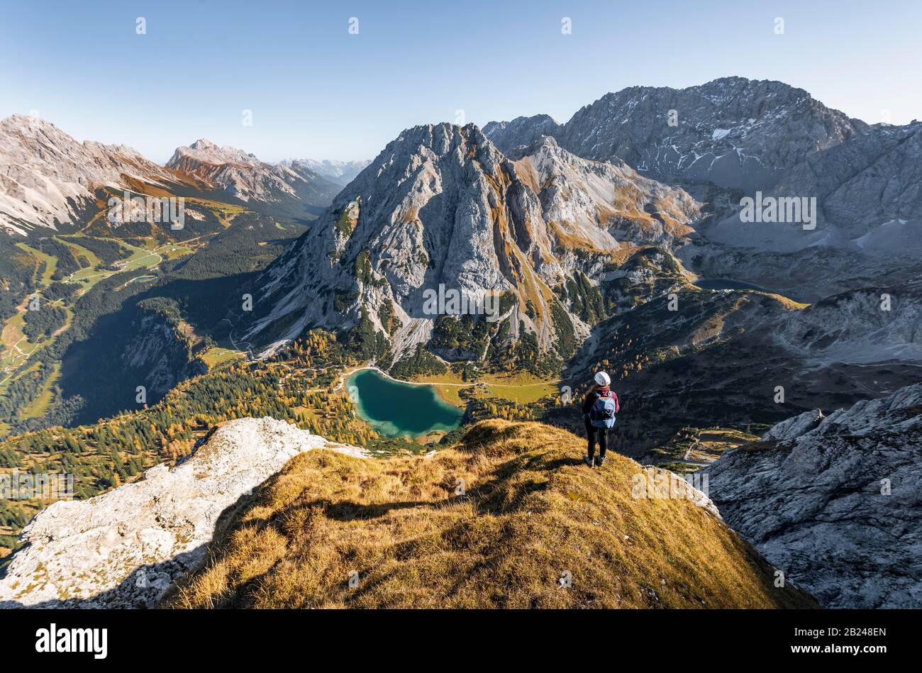 Junge Frau mit Kletterhelm mit Blick auf den Seebensee von der Ehrwalder Sonnenspitze, links Leutaschtal, Mitte Vorderer und Hinterer Tajakopf, rechts Stockfoto