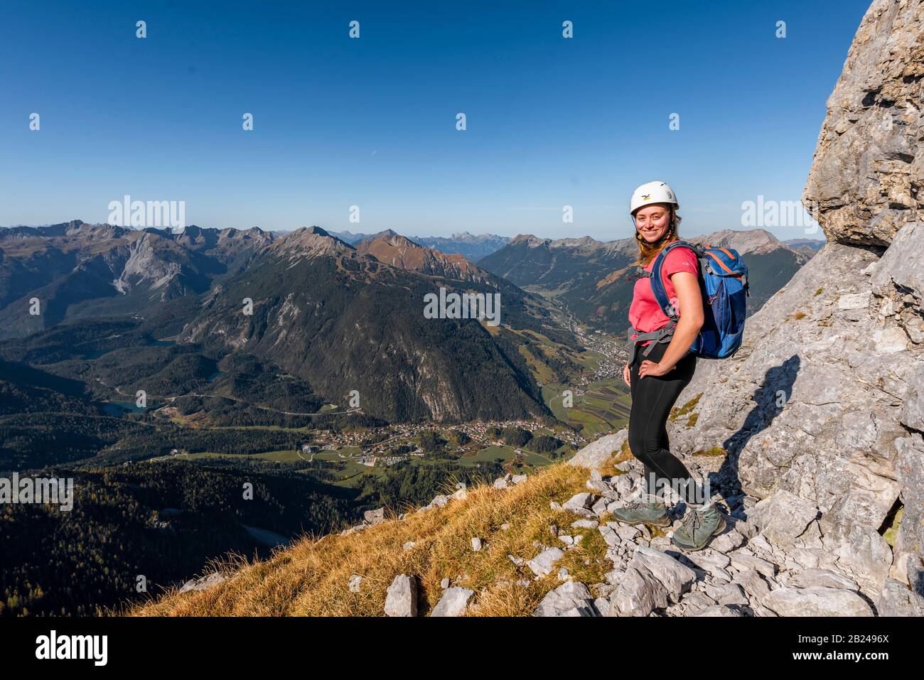 Junge Frau, Bergsteigerin mit Kletterhelm mit Blick auf die Berglandschaft, Wanderung zur Ehrwalder Sonnenspitze, hinter Gruenstein und West Stockfoto