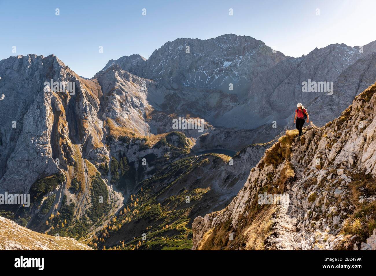 Bergsteiger mit Kletterhelm, der auf einem steilen Berghang verläuft, Wanderweg zur Ehrwalder Sonnenspitze, Ehrwald, Mieminger Kette, Tyrol, Österreich Stockfoto