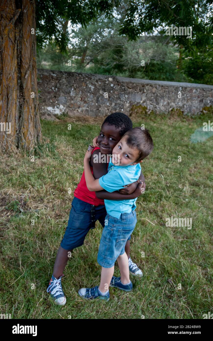 Weißer Junge und schwarzer Junge umarmen Stockfoto