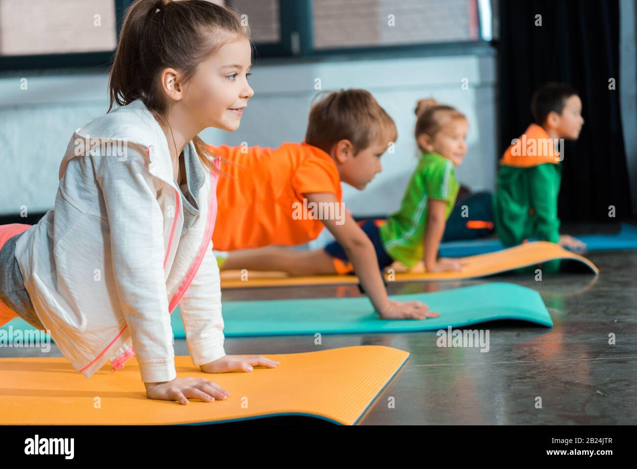Selektiver Fokus multikultureller Kinder, die Asana auf Yogamatten machen Stockfoto