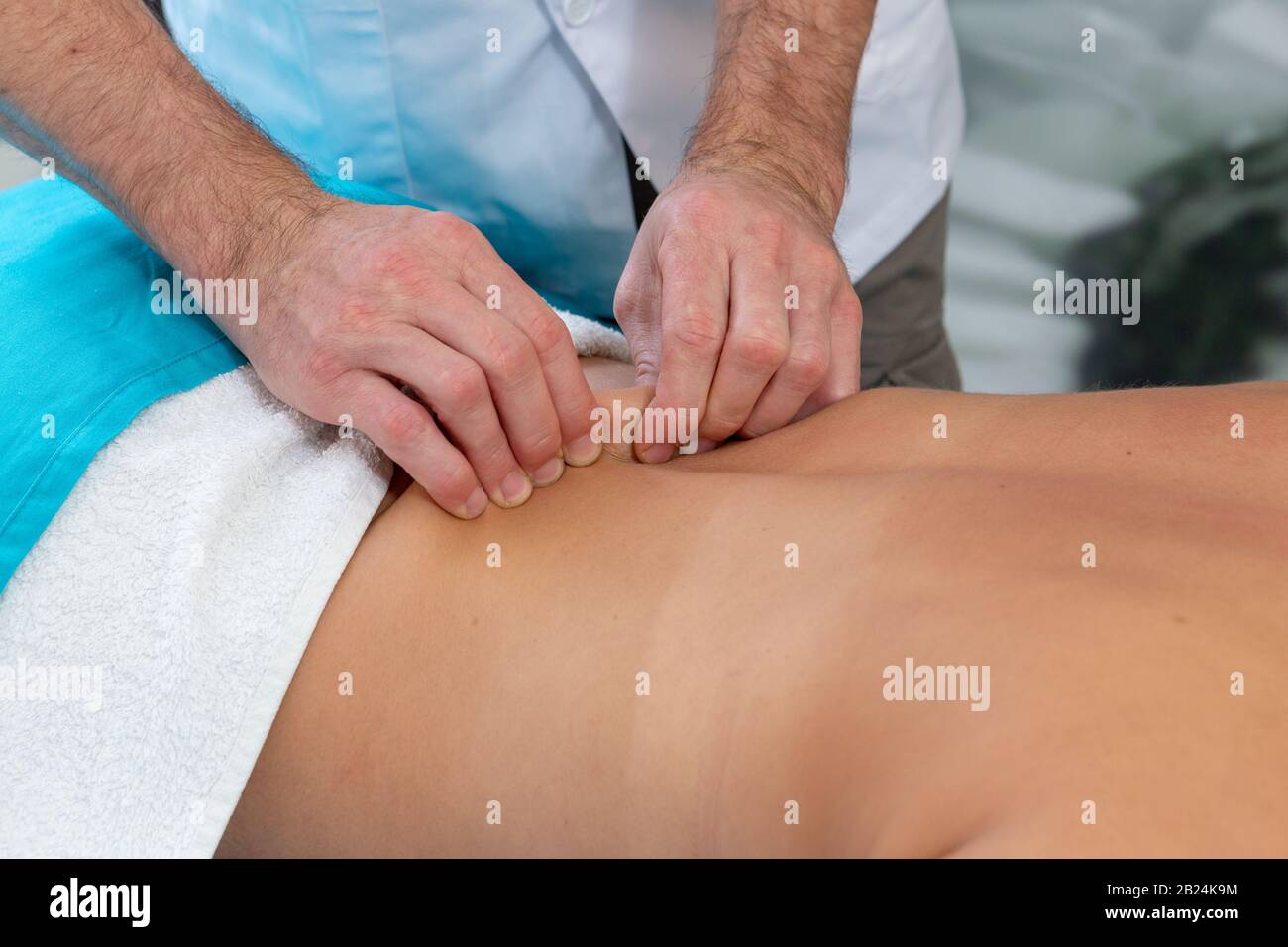 Osteopath massiert den Patienten auf dem Rücken. Straffen der Haut Stockfoto