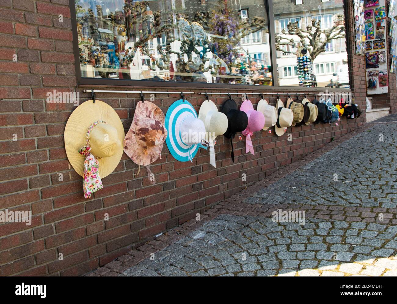 Schöne, mehrfarbige Sommer-Modenhüte aus natürlichen Materialien sind im Sommer bei sonnigem Wetter auf der Straße der antiken Stadt im Handel. Ou Stockfoto