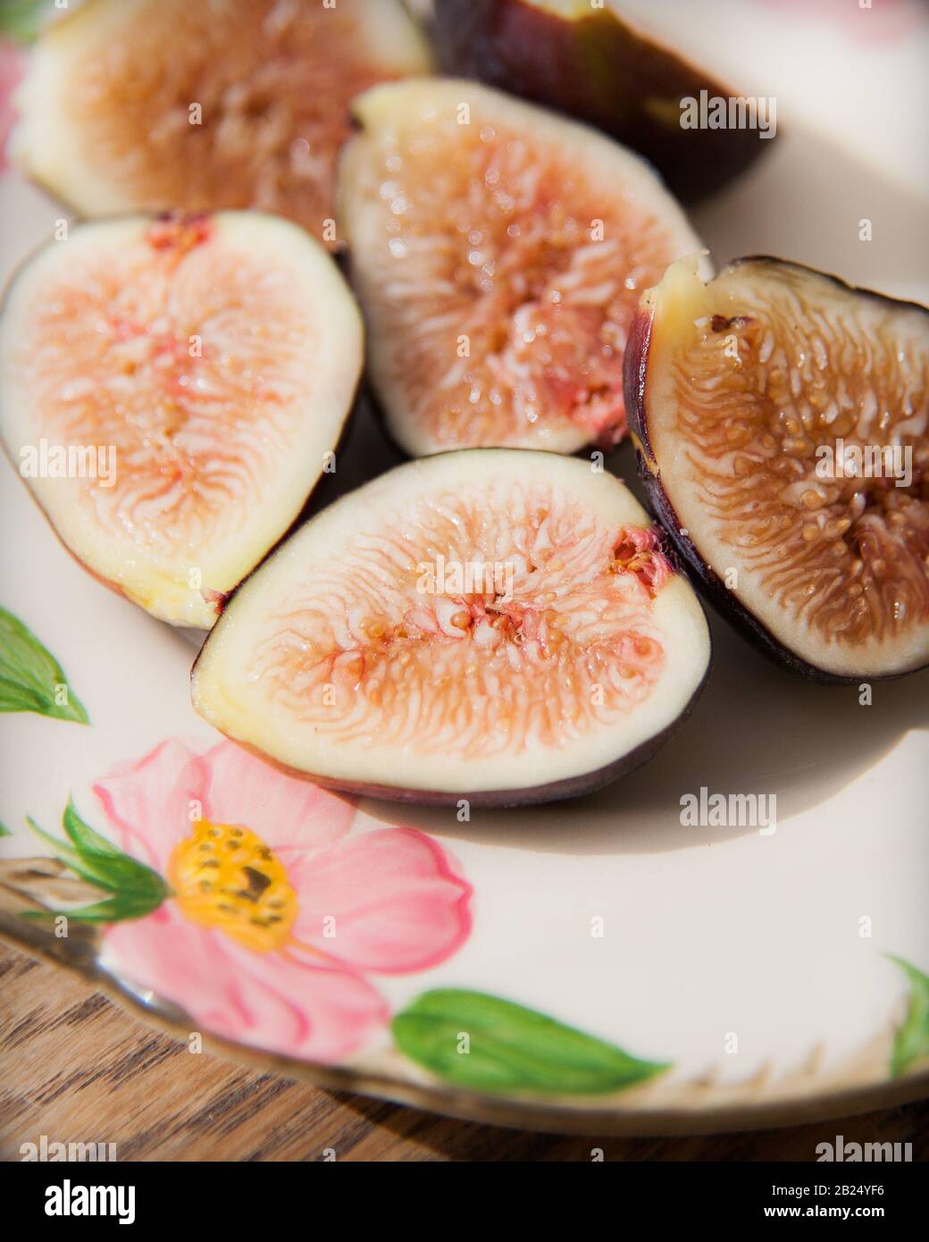 Nahaufnahme von Halbierten Figs auf einer Blumenmusterplatte Stockfoto