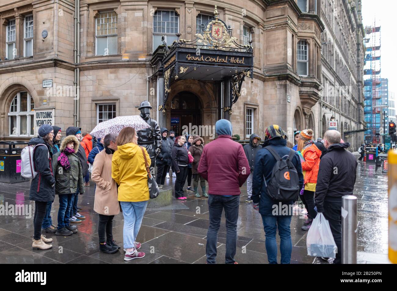 Touristen mit Reiseleiter im Regen in Glasgow, Schottland, Großbritannien Stockfoto