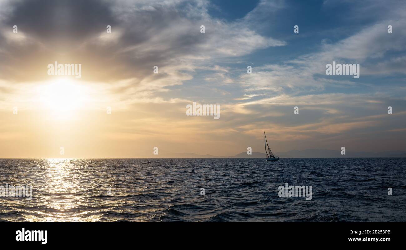 Silhouette Segelboot gleiten bei Sonnenuntergang im offenen Meer. Abends geneigter Monohull. Luxus-Sommerabenteuer, Aktivurlaub im Mittelmeer Stockfoto