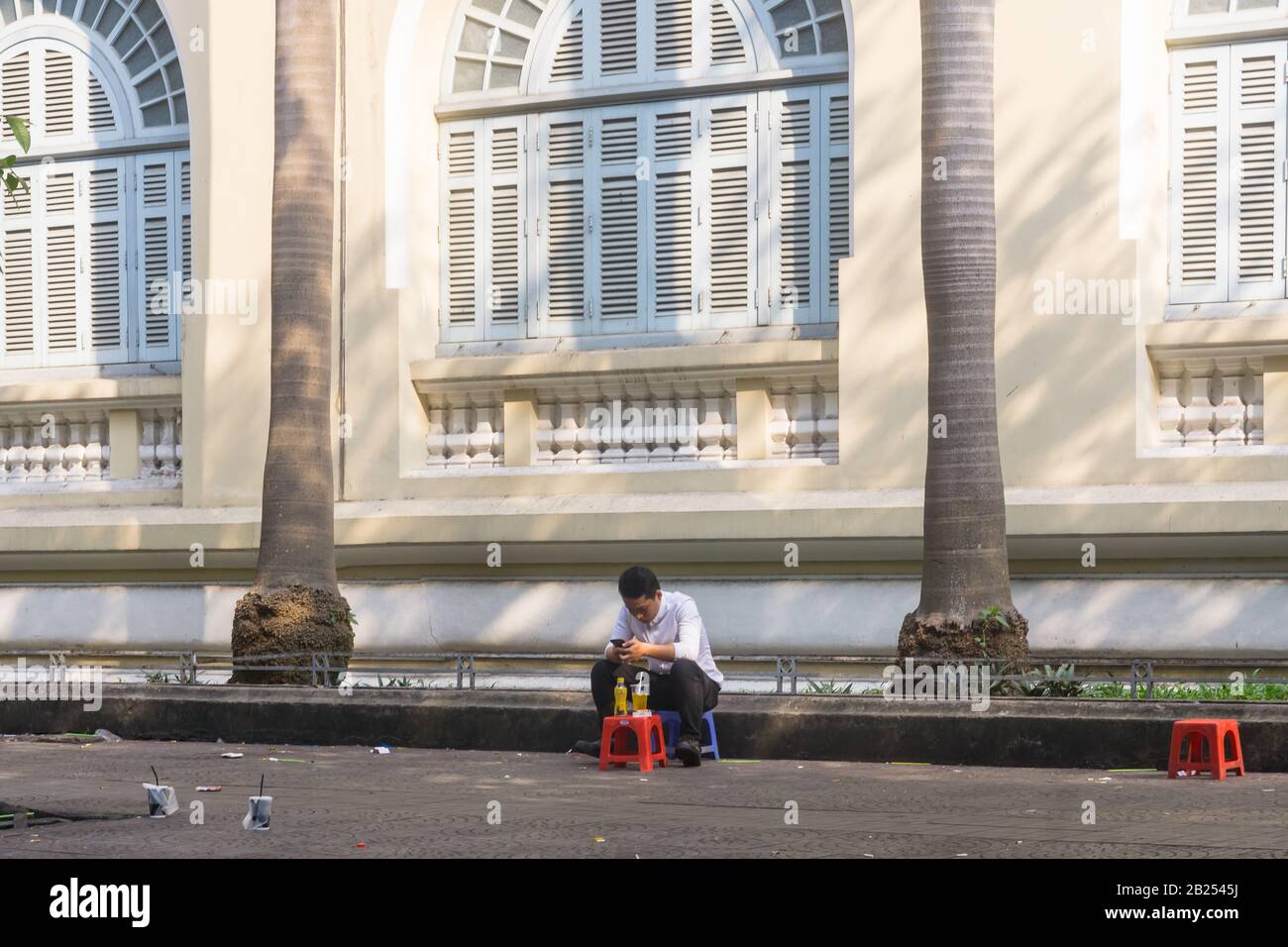 Saigon (Ho-Chi-Minh-Stadt) - EIN vietnamesischer Mann, der auf der Straße in Saigon, Vietnam, Südost-Asien einen Drink auf dem Hocker hat. Stockfoto