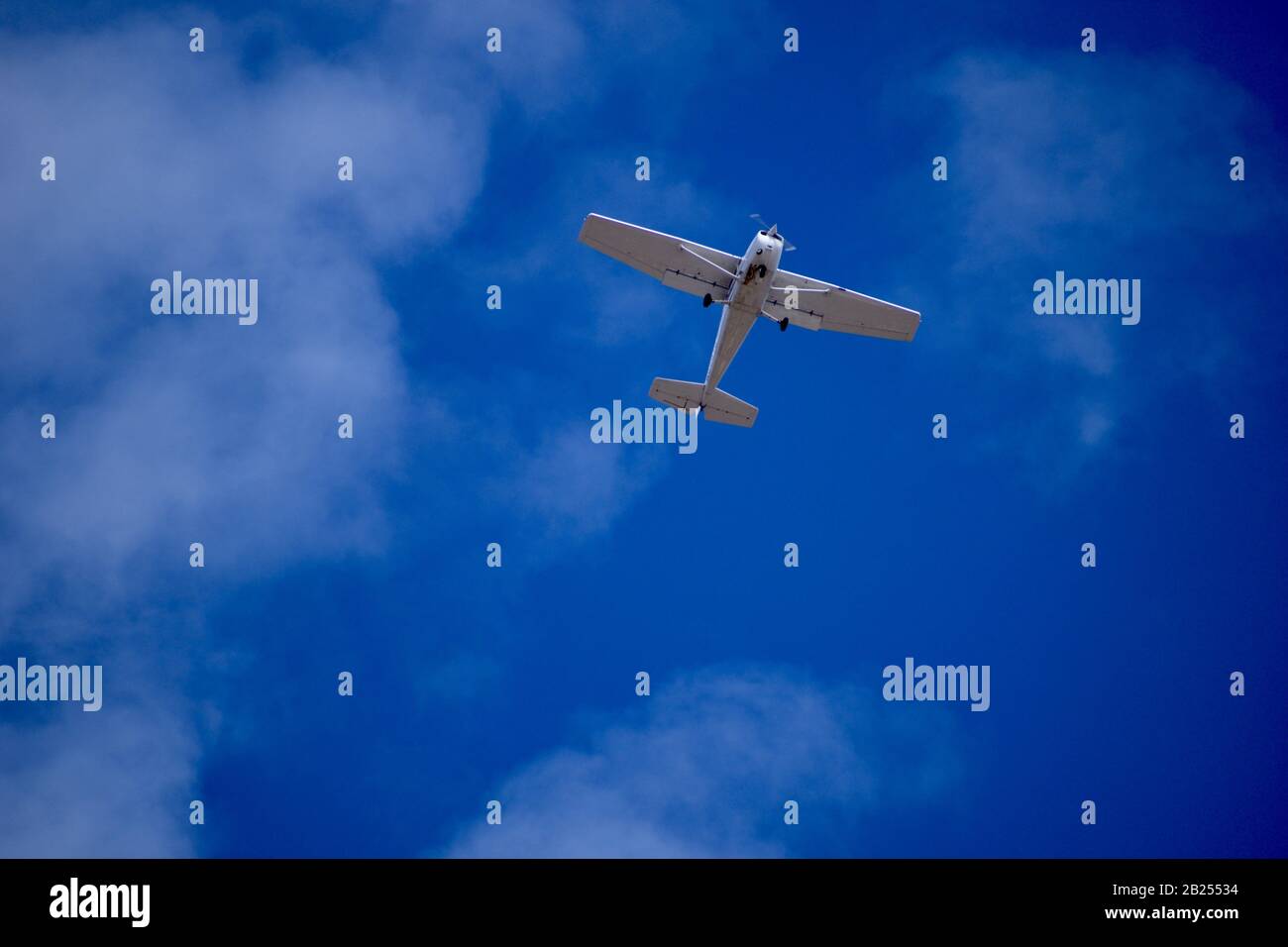 Unterseite des kleinen weißen Flugzeugs, das über eine Stadt in Arizona, Vereinigte Staaten, fliegt Stockfoto