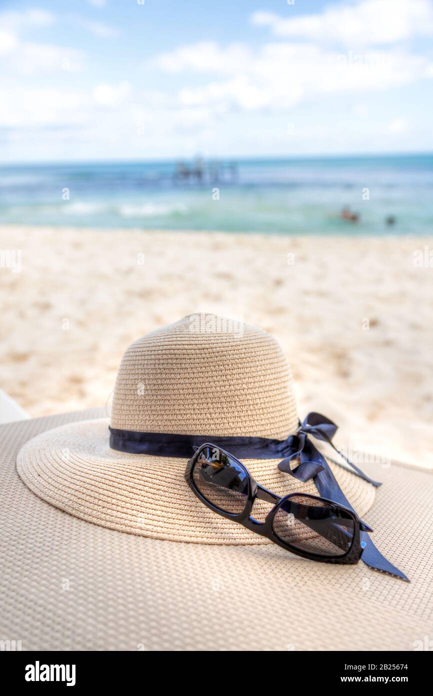 Urlaubsthema mit Sonnenbrille und Hut im tropischen Strandhintergrund mit Meer und blauem Himmel. Kopierbereich. Stockfoto