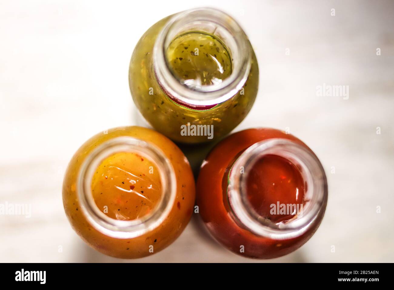 Drei Flaschen Soßen: Heiß, Tomatoe und Kräuter von oben. Stockfoto