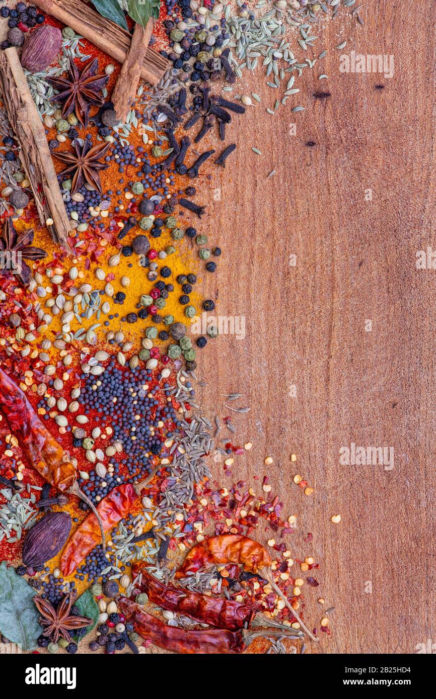 Aromatische Gewürze auf einem Holzbrett zur Seite des Rahmens Stockfoto