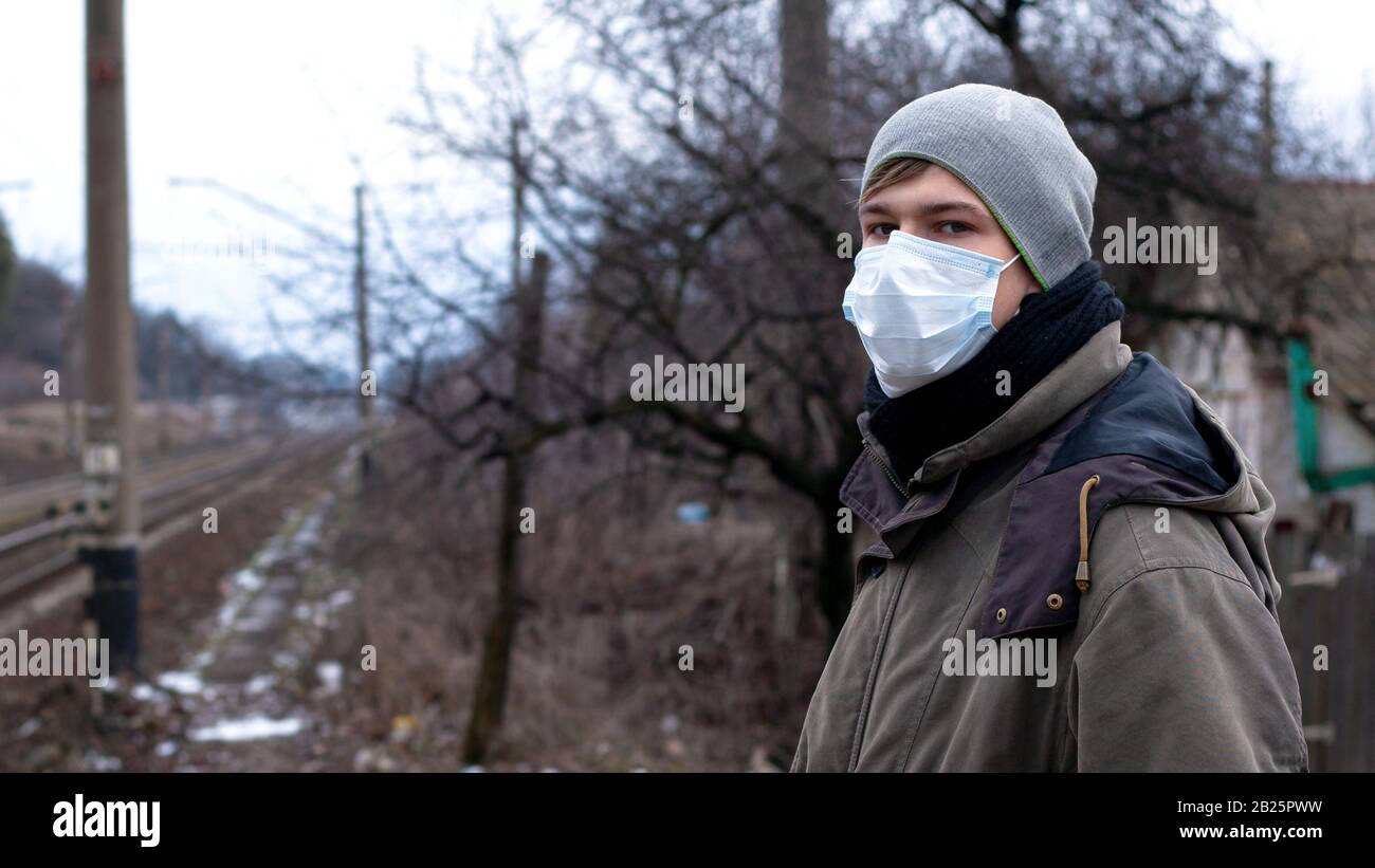 Junger Mann in medizinischer Einwegmaske in der Nähe der Station.Viral Disease Protection Grippe, SARS, Covid-19. Stockfoto