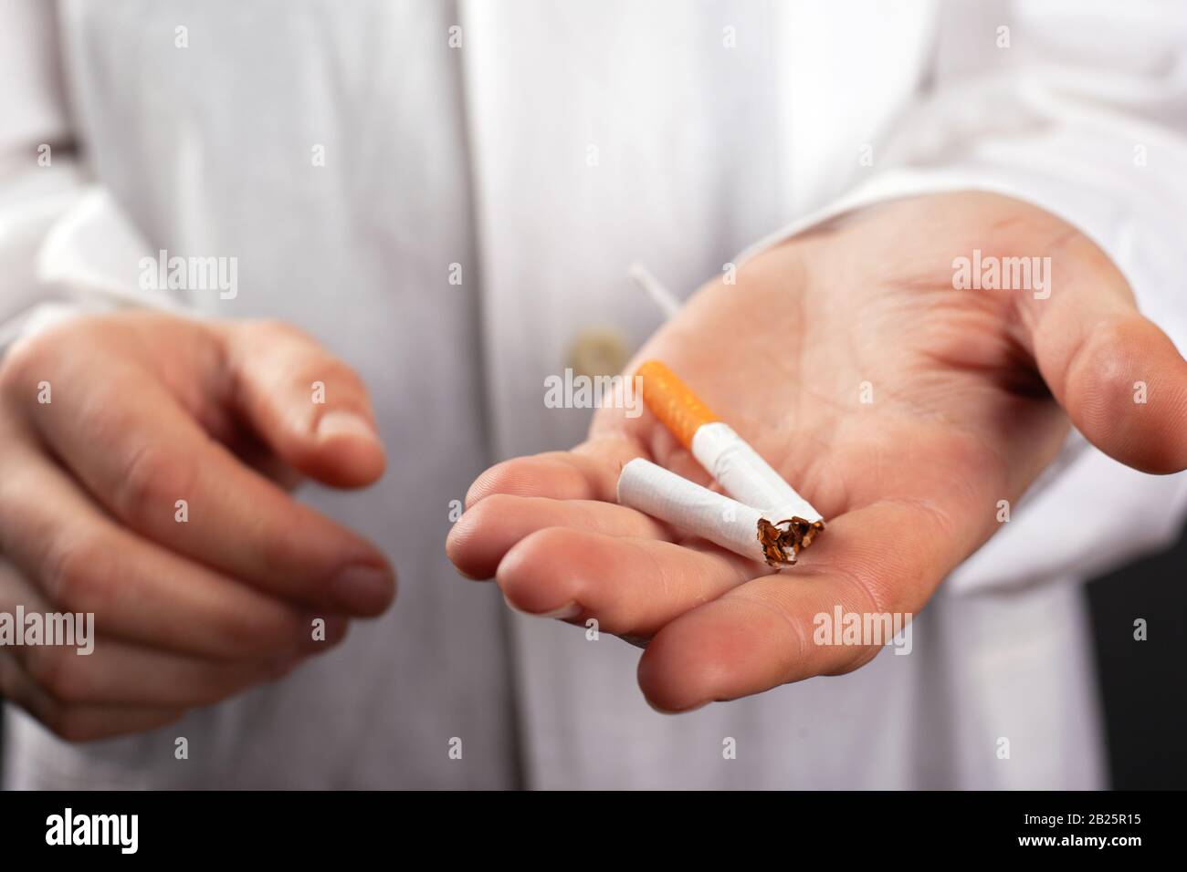 Doktor hält eine defekte Zigarette in der Hand. Schaden durch Rauchen. Lungenkrebserkrankung Schaden durch Nikotin. Stockfoto