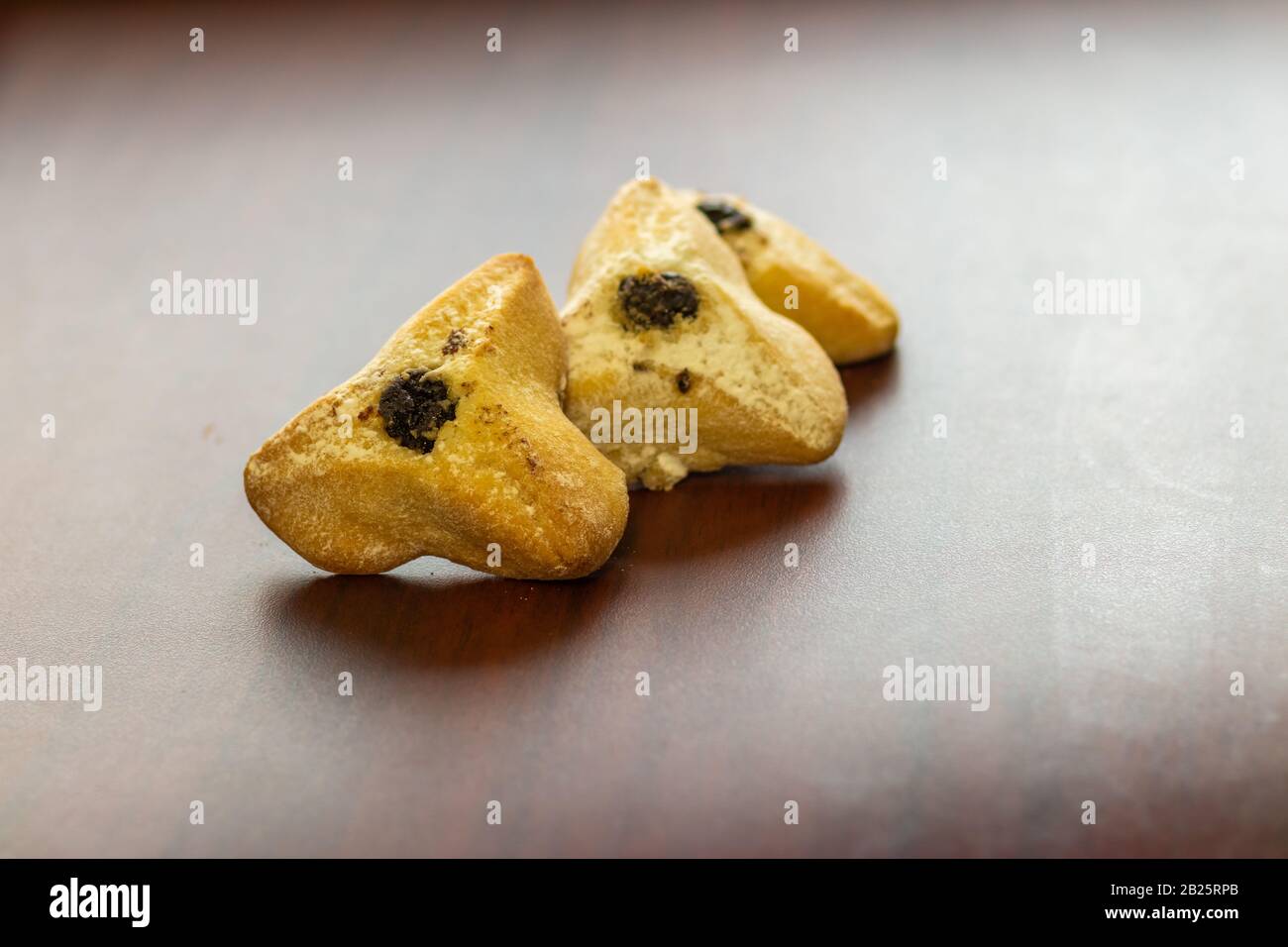 Ozney haman (Haman Ohr) Dreikantgebäck aus knusprigen Teig gefüllt. Traditionelle jüdische Küche für Purim. Befindet sich auf einer Holzoberfläche Stockfoto