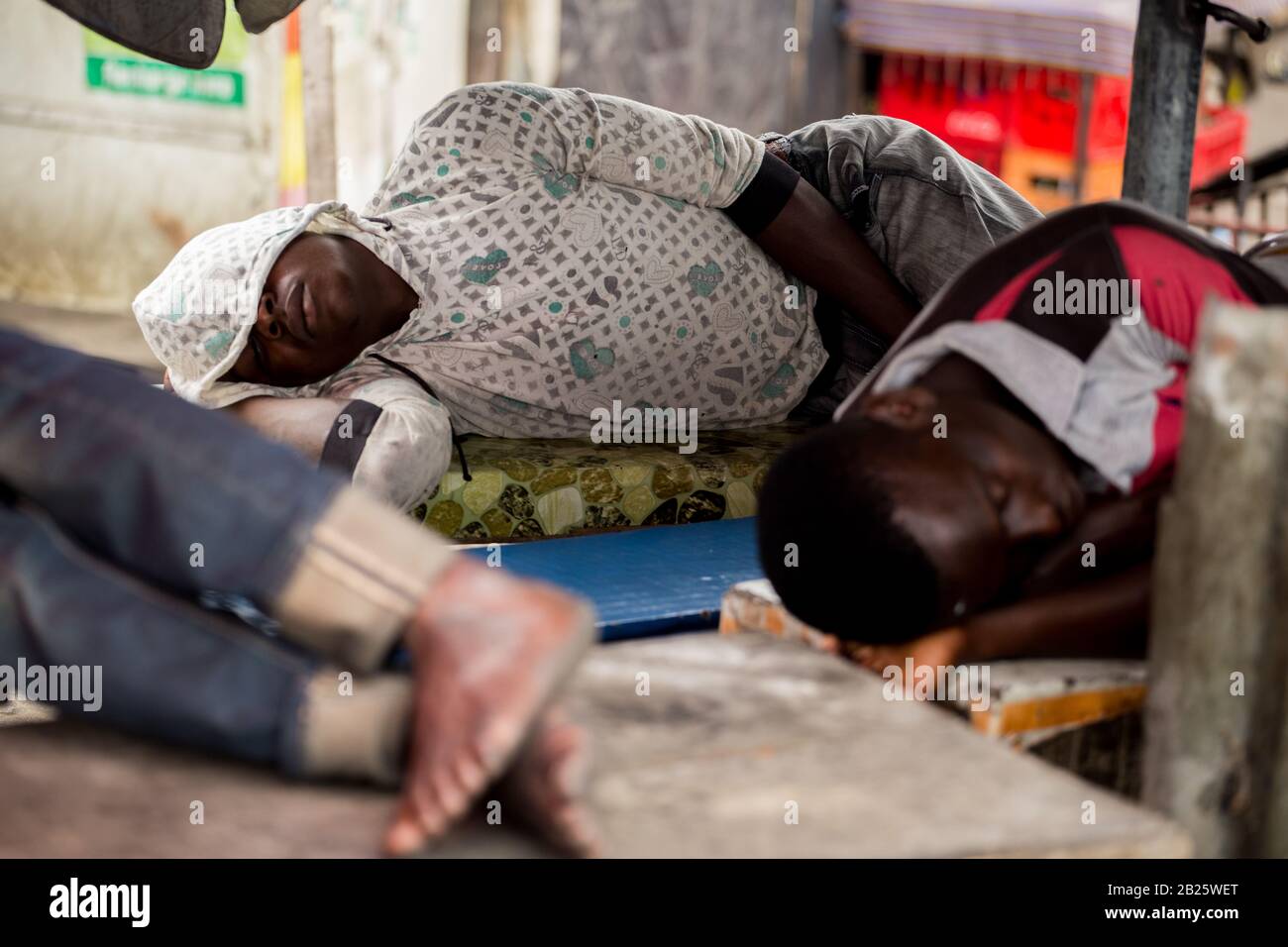 Menschen, die öffentlich auf einer Straße in Nigeria schlafen. Stockfoto