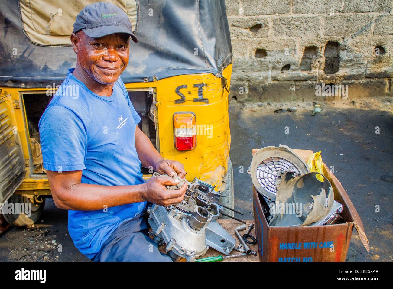 Ein Rikscha-Mechaniker auf einer Straße in Nigeria. Stockfoto