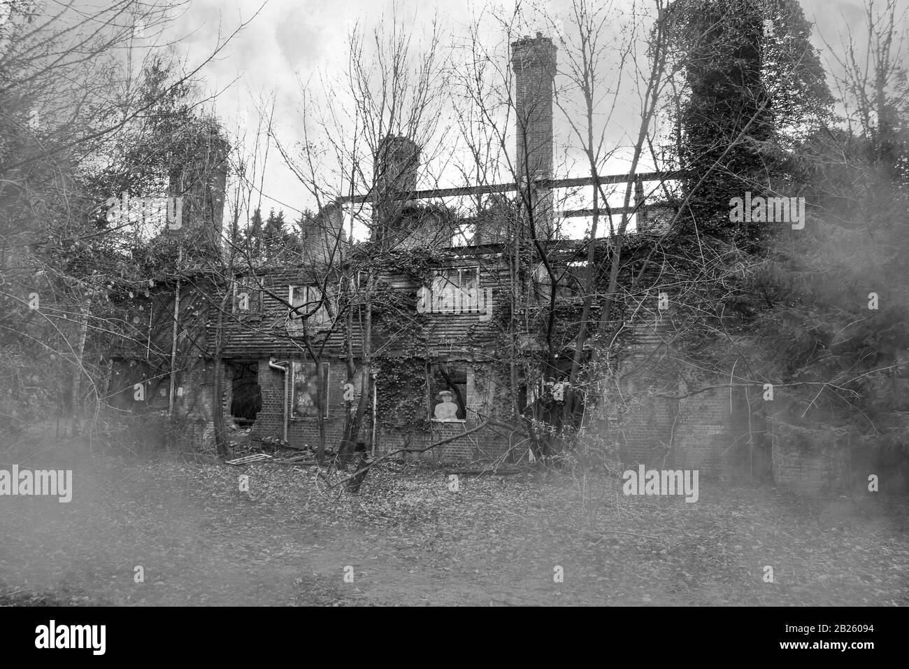 Die Ruinen eines alten Hauses tief im Wald, das einst als Hotel genutzt wurde, aber vor langer Zeit nach einer Auseinandersetzung zwischen einer Frau und einem Ehemann brannte Stockfoto