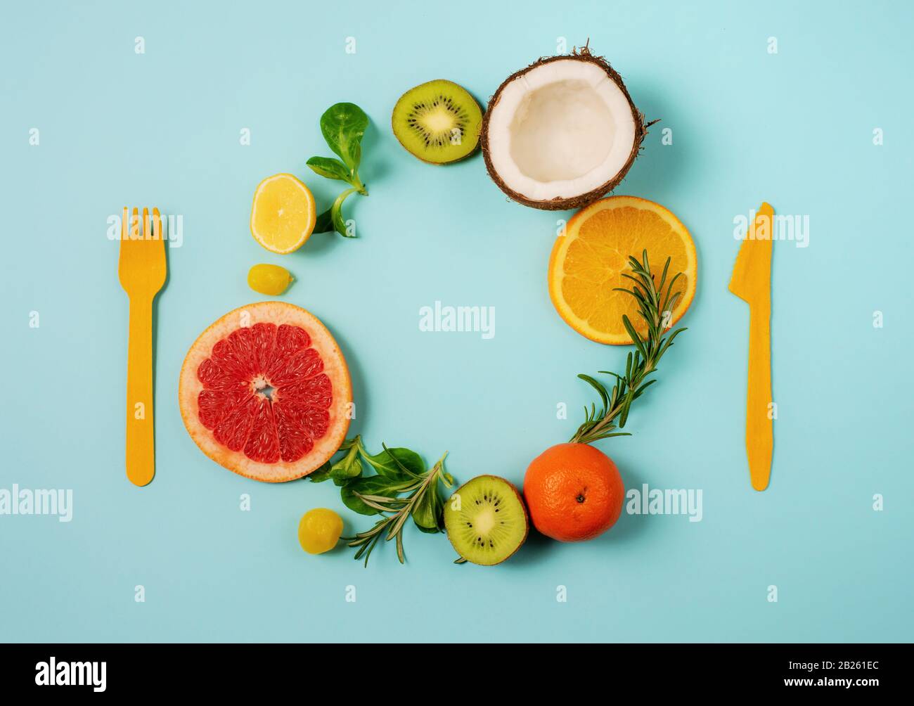 Zusammensetzung von Zitrusfrüchten, Orange und Zitrone, Kokosnuss, Kiwi auf zyanischem Hintergrund Stockfoto