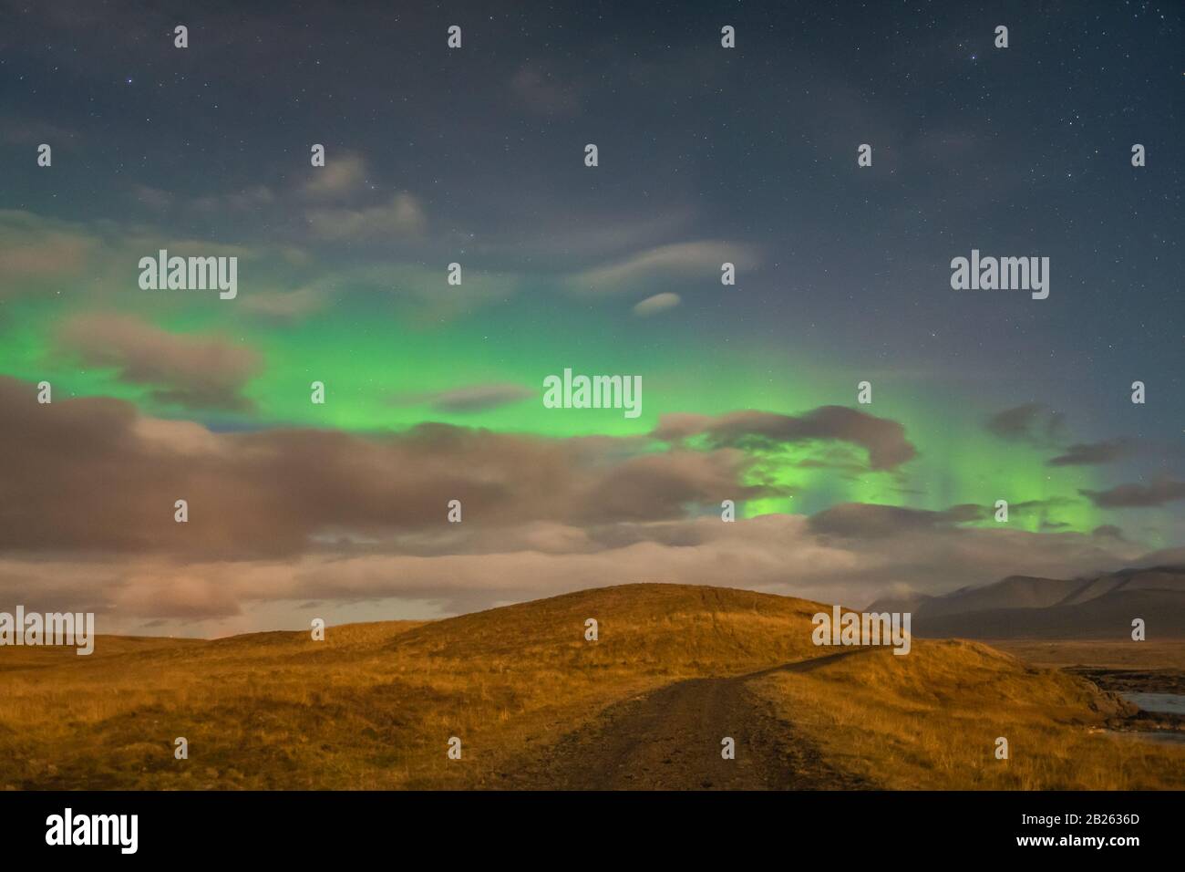 Aurora in Island Nordlicht helle Strahlen über Wolken während des Vollmonds Stockfoto
