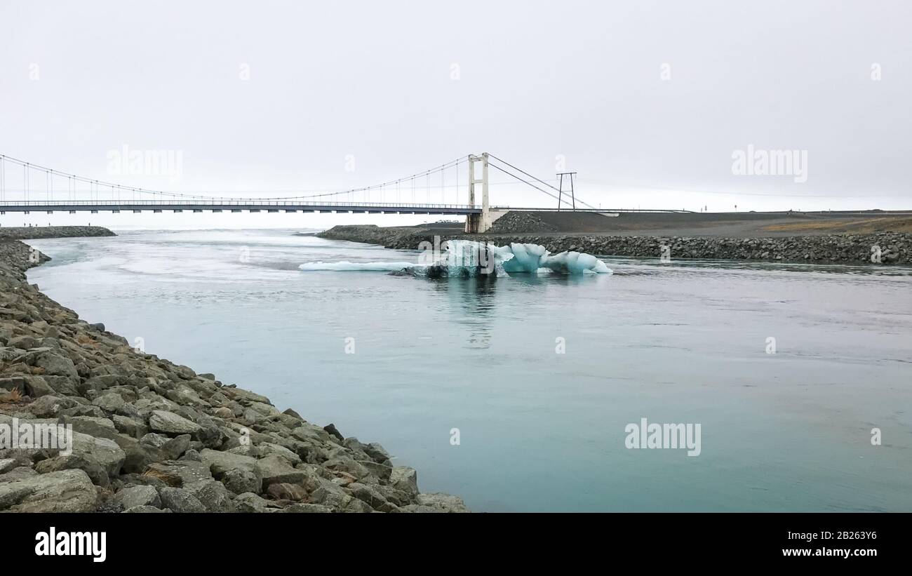 Joekulsarlon Glacier Lagoon tiefblaue Eisberge vor alter Hängebrücke Stockfoto