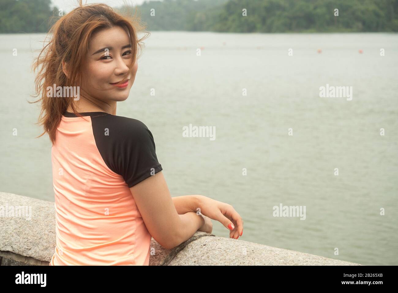 Asiatisch-chinesisches Mädchen in ihrem Sportoutfit lächelnd und posiert nach dem morgendlichen Workout für die Kamera Stockfoto
