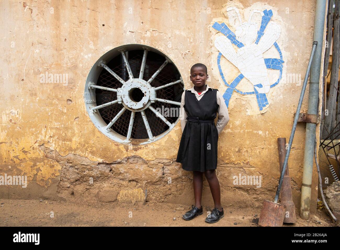 Mädchen neben Mosaik im Handwerkerzentrum von Morija, Lesotho Stockfoto