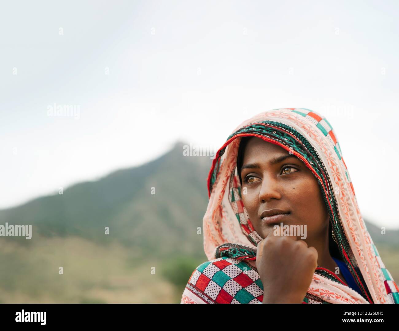 Junge Zigeunerfrau in traditioneller farbenfroher Kleidung und lächelndes gehen in der Wüste Thar im Morgengrauen bei Puschkar, Rajasthan, Indien. Stockfoto