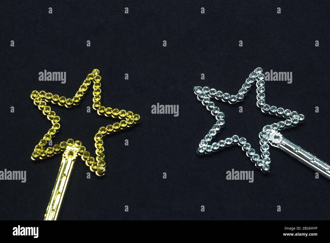 Zwei magische Wanden in goldener und silberner Farbe mit einem Stern oben mit Glitzersteinchen. Spielzeug für Kinder aus Kunststoff auf schwarzem Hintergrund. Stock-Foto für Webdruck, zurück Stockfoto